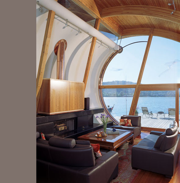 Curved wood ceiling and a large circular window in the living room provide water views and natural light.