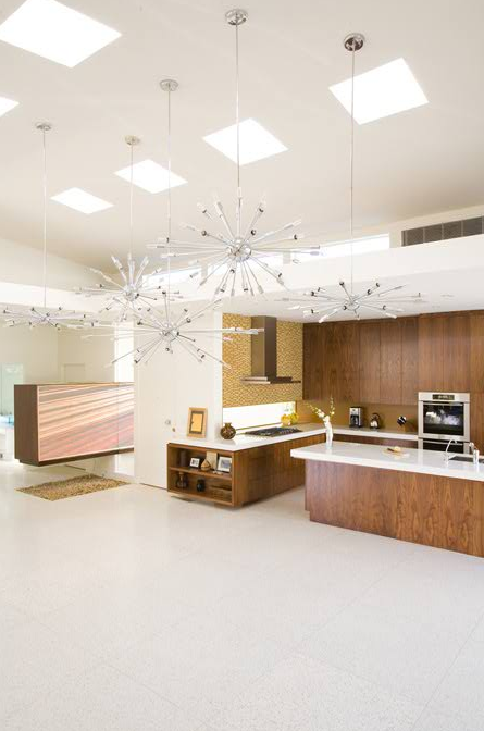 Modern kitchen featuring wooden cabinets, white countertops, an island, and skylights in the ceiling.