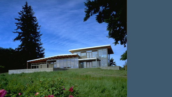 Exterior front view of the Bruckner Residence showing large windows and flat roof design.