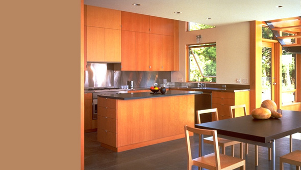 Kitchen and dining area in the Bruckner Residence featuring wood cabinets, stainless steel backsplash, and sliding glass doors.