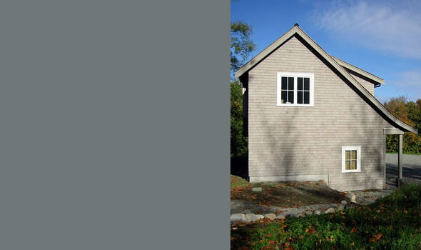 Side elevation of a gable-roofed garage with wooden shingles and two windows.