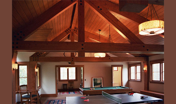 Recreational room with exposed timber structure and vaulted ceiling.