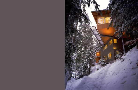 Cascade Lake House by E. Cobb Architects Inc. shows its cantilevered upper level amid snow-covered trees in Seattle.