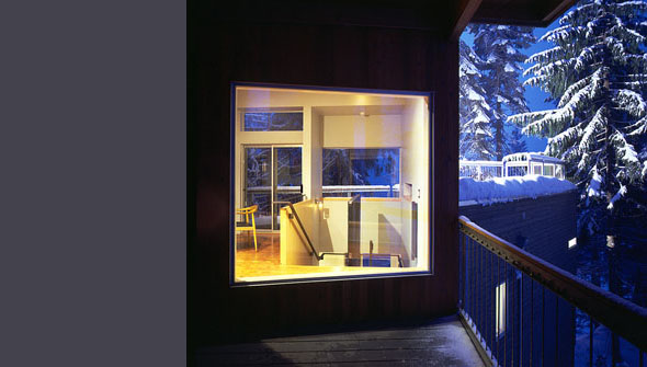 Window view of interior staircase and built-in furniture at Cascade Lake House by E. Cobb Architects Inc.