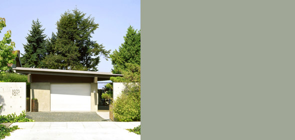 Front exterior of a modern residential garage with a flat roof and landscaped surroundings.