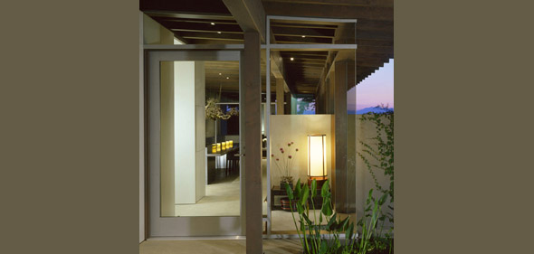 The entryway features exposed beams and a vertical lantern fixture during dusk light.