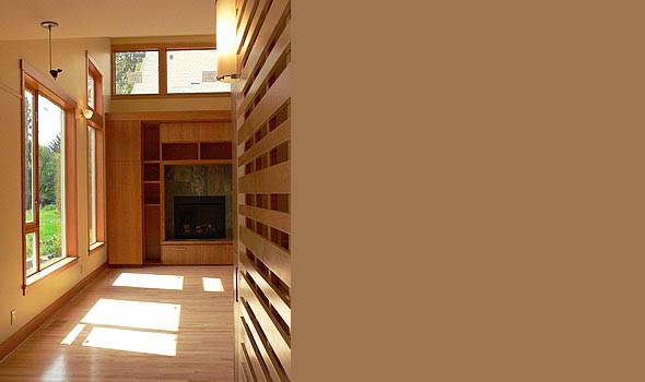 Hallway features hardwood floors and built-in wood shelving around a fireplace with a clerestory window above.