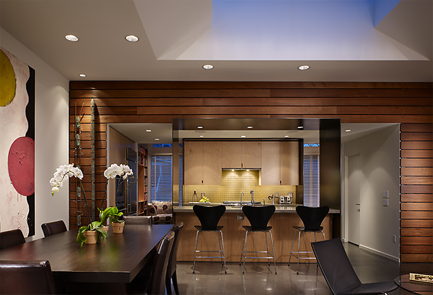 Madrona Live / Work project features a wood-paneled kitchen with a triangular skylight and polished concrete floor.