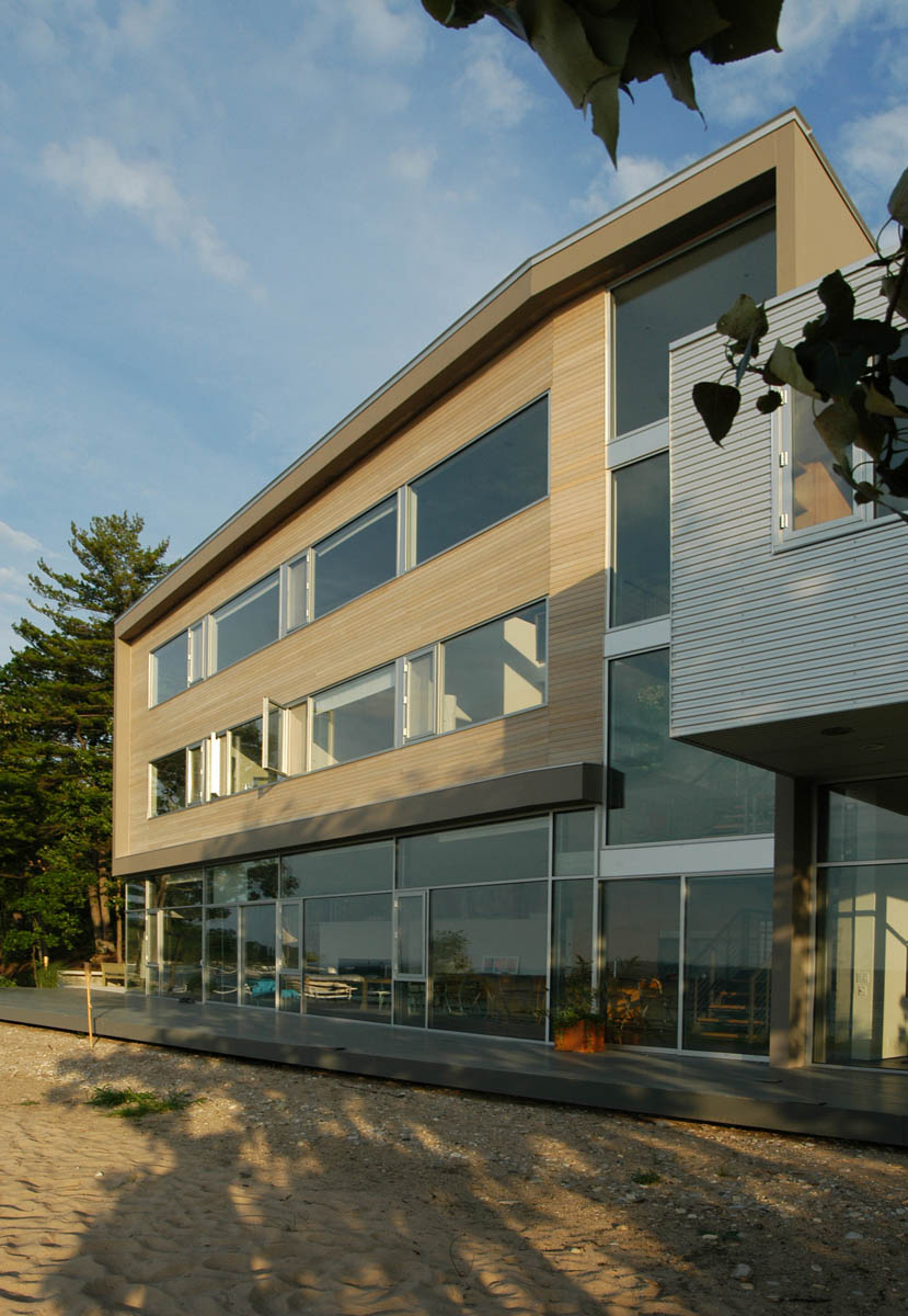 Exterior front view of Michigan Residence featuring horizontal strip windows and wood cladding.