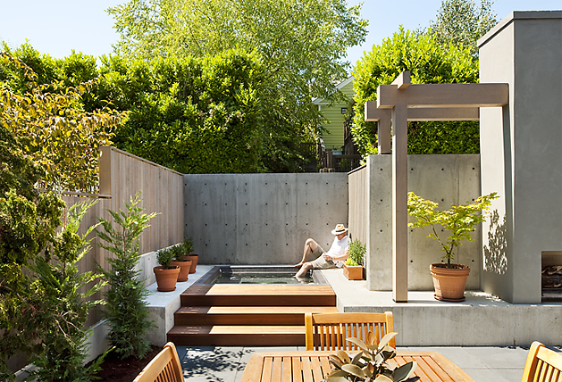 Mt Baker Courtyard features a concrete pool surrounded by concrete walls, wood pergola, and wooden outdoor furniture.