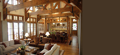 Living and dining room with exposed beams and floor-to-ceiling windows.