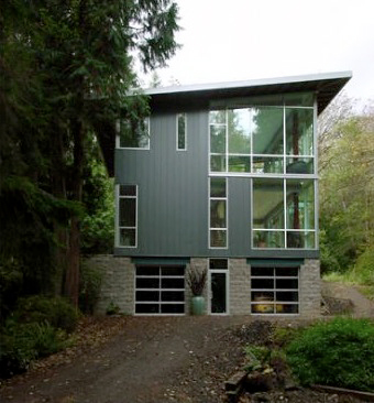 The Cala Woods Residence features black window frames and board-formed concrete base with metal mesh railing on upper floors.