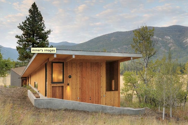 Miner's Refuge by Johnston Architects PLLC features wood siding and a flat roof with mountain views in the background.