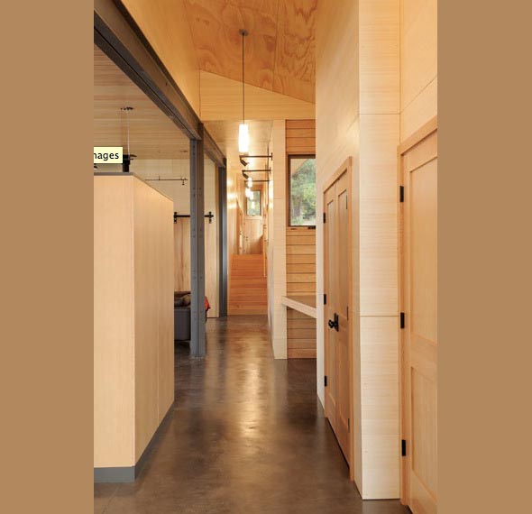 Interior hallway with polished concrete floor, wood paneling, and recessed lighting.