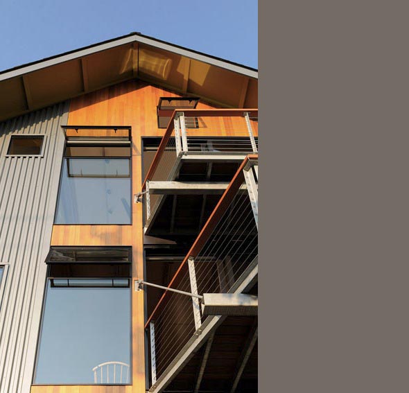 The Belyea-Faigin project features wood and metal siding with balconies and black window frames under a gable roof.