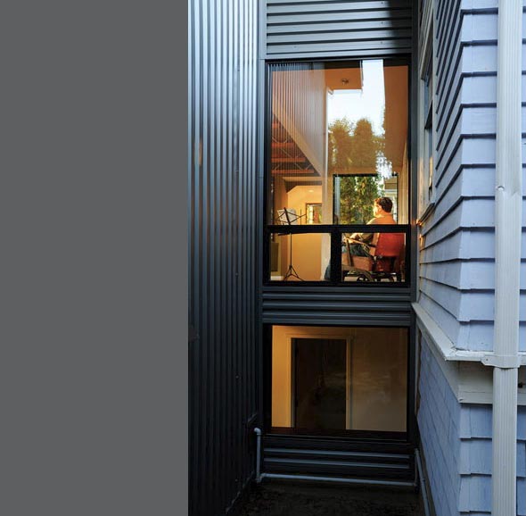 Two vertically stacked windows reveal interior spaces of the Belyea-Faigin residence by Johnston Architects PLLC.