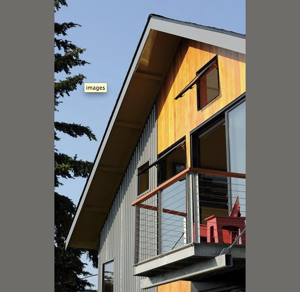 Modern house exterior featuring vertical wood and metal siding, a cable railing balcony, and operable windows under a gable roof.