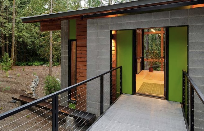 Entrance walkway of the Schell-Wheeler house featuring concrete block and wood siding with green door panels.