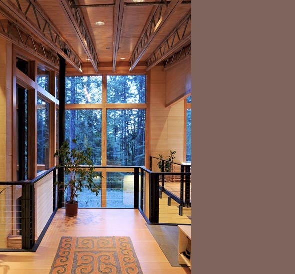 Mezzanine level with wood beams and cable railing overlooks the forest through a large window in the Schell-Wheeler project.