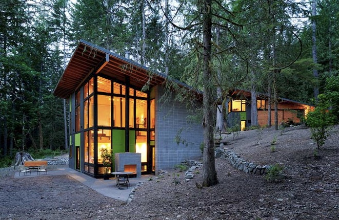 Exterior of the two-story Schell-Wheeler house in a forest setting with mixed siding and floor-to-ceiling glazing.