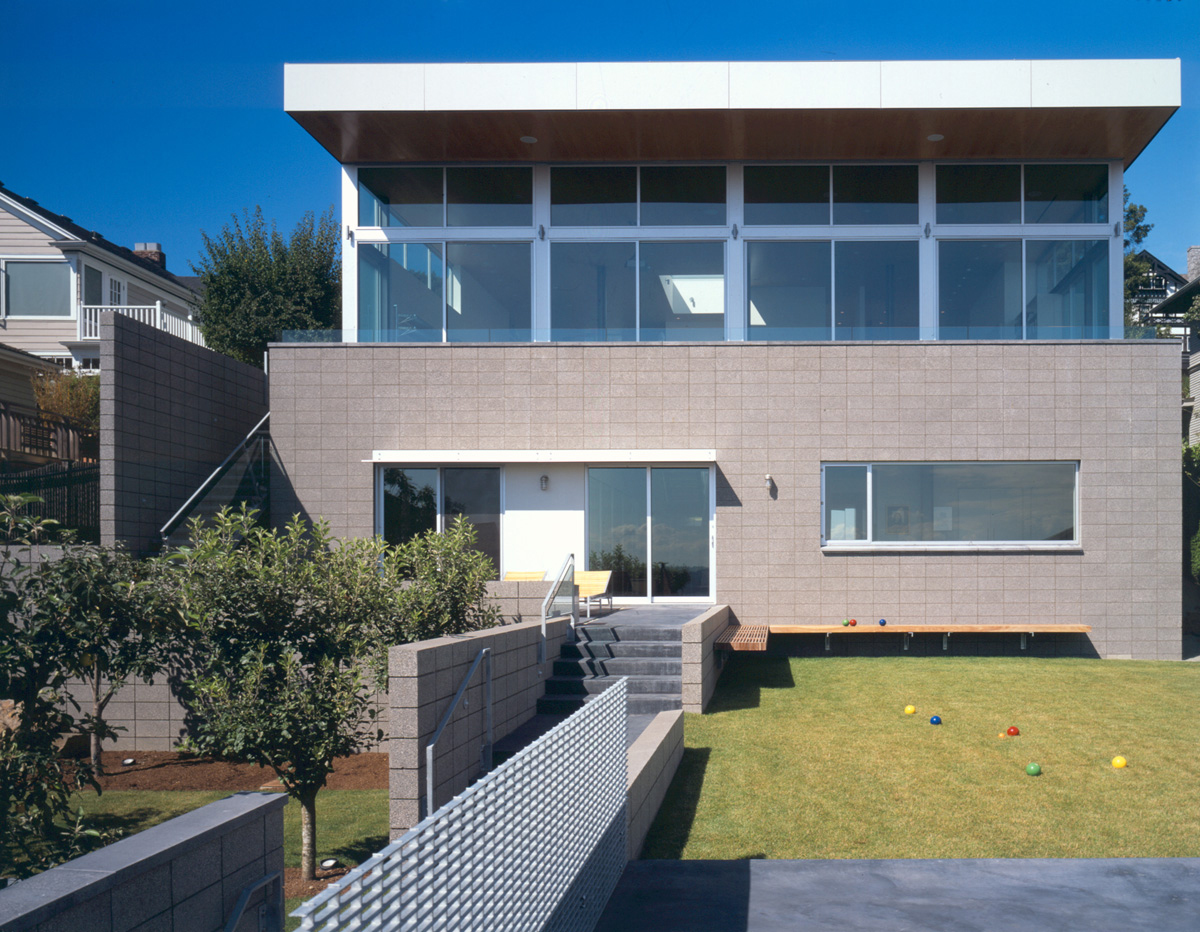 Modern rear facade of the Casper Residence features expansive second-floor glazing and concrete block masonry below.