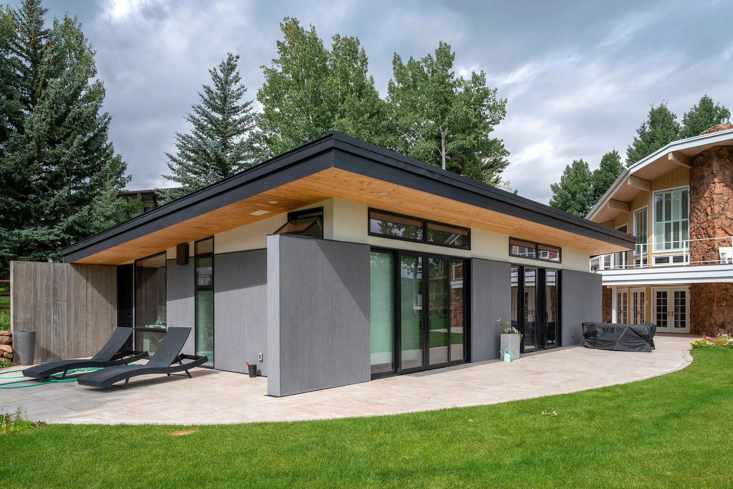 Meadowood Guesthouse features a modern flat-roof design with large black-framed windows and wood soffit details.