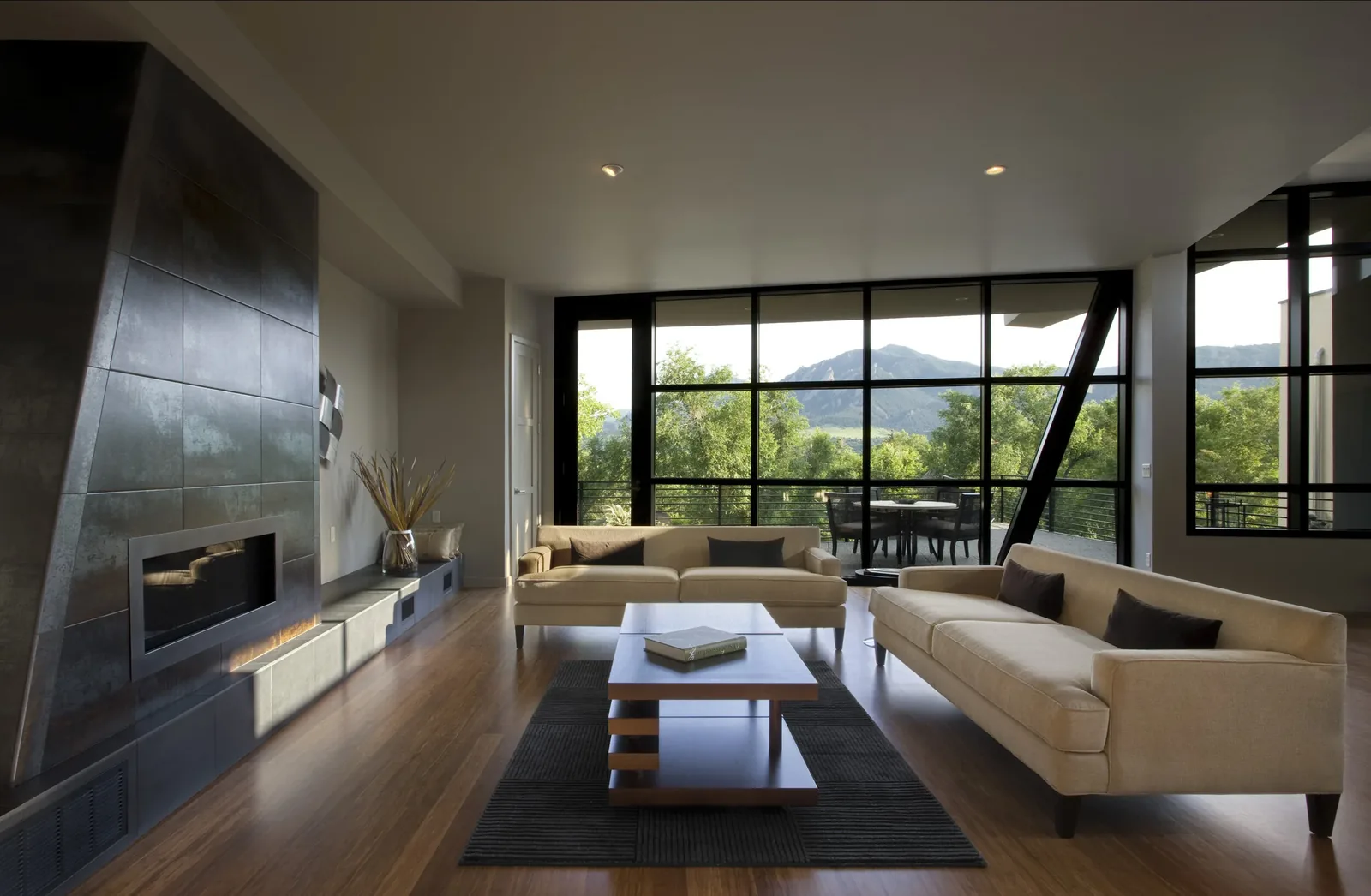 Living room with floor-to-ceiling glazing overlooks a landscape with mountains in the distance