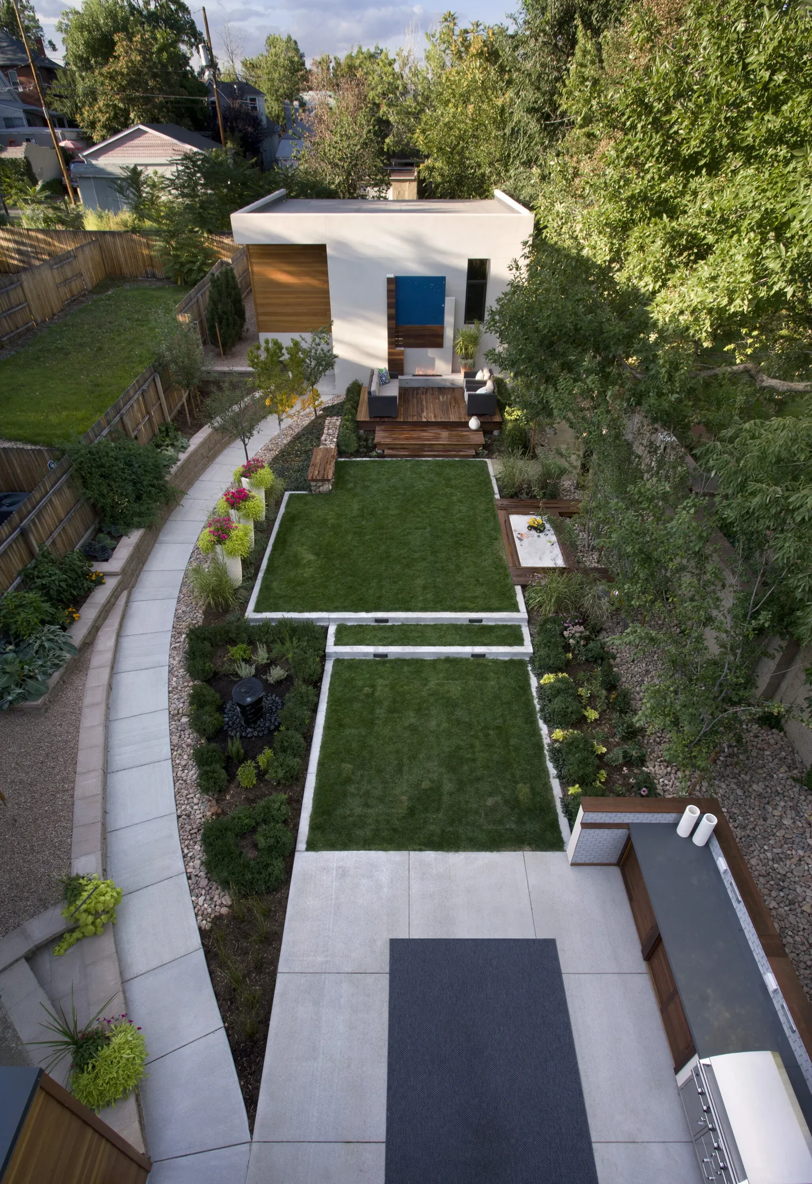 Backyard garden and outdoor living area with a modern small building and walkway.