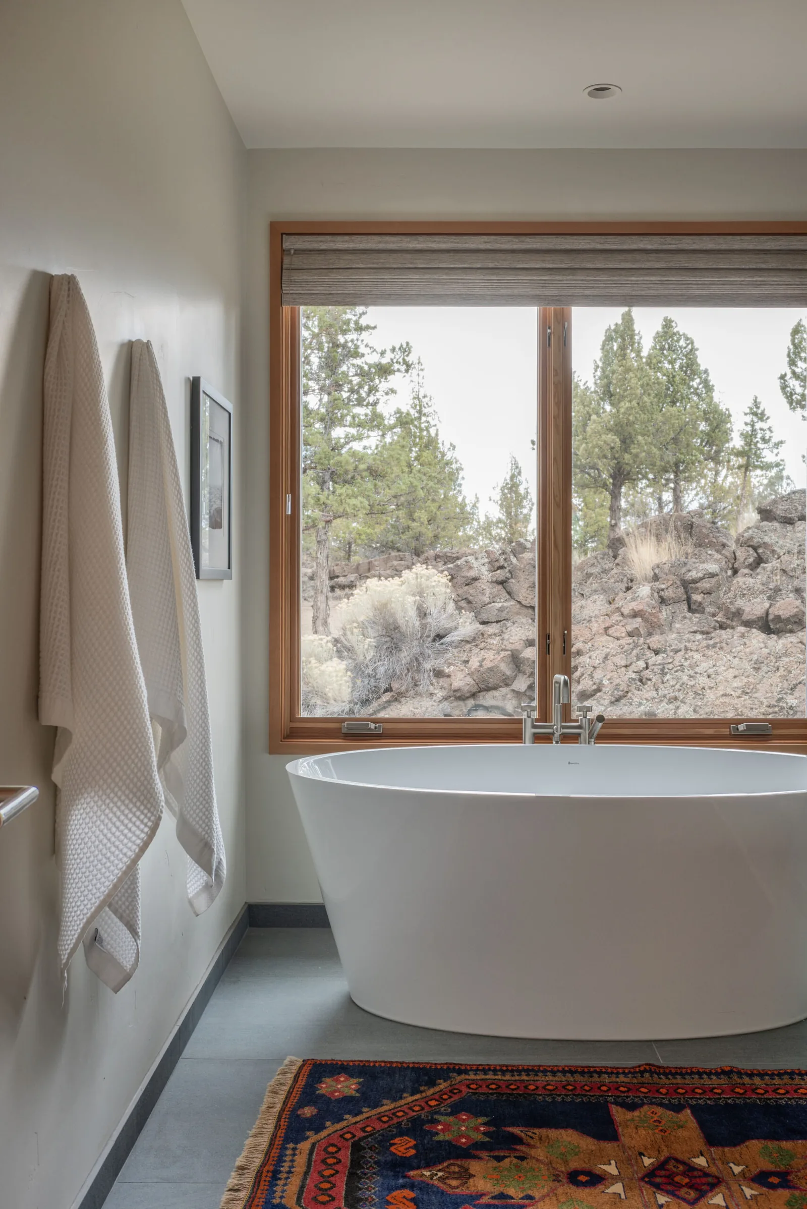 Bathtub with floor-to-ceiling window showcasing desert landscape in Deschutes Modern Oasis project.