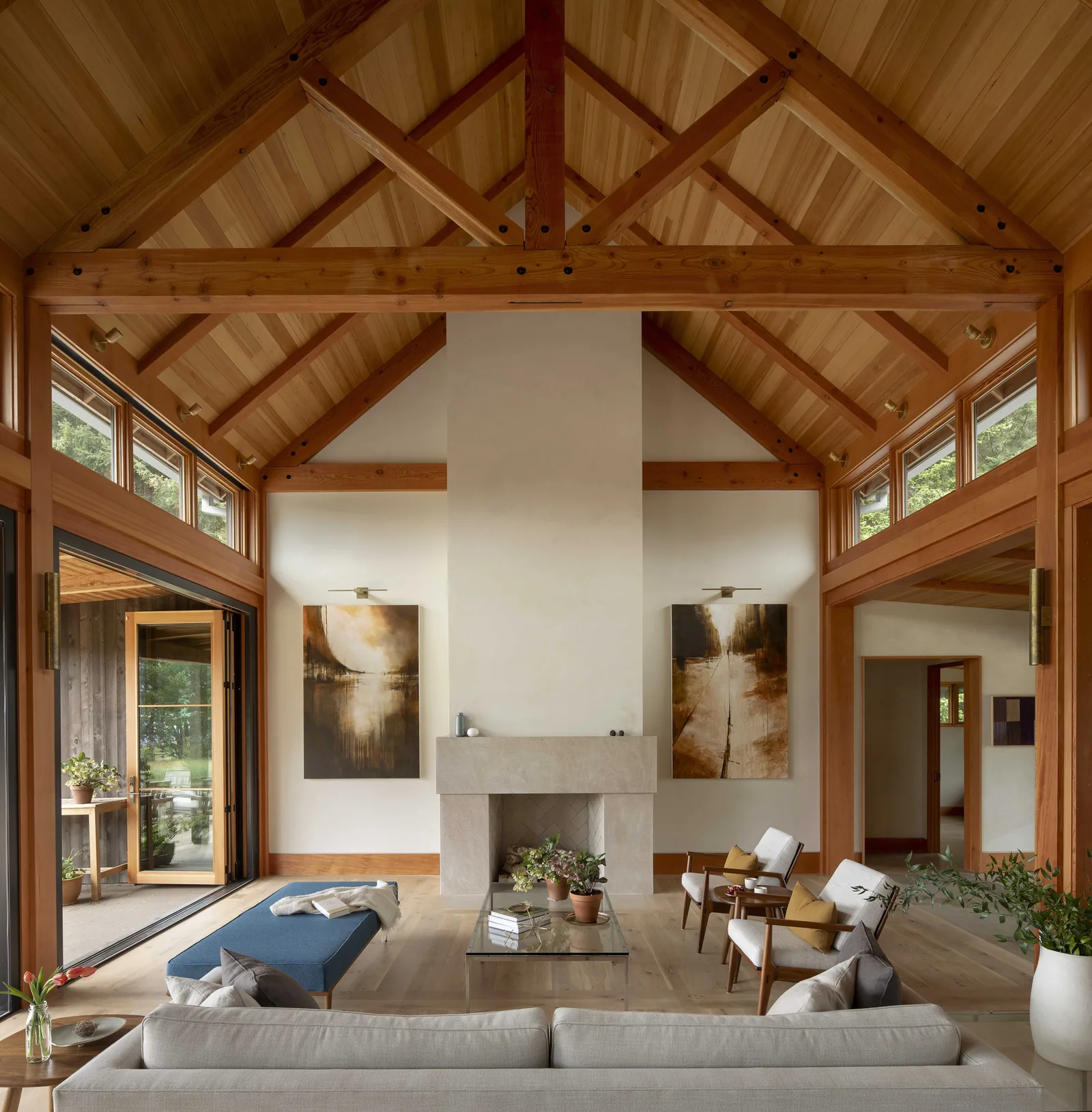 Living room featuring a vaulted ceiling with exposed beams and a central fireplace.