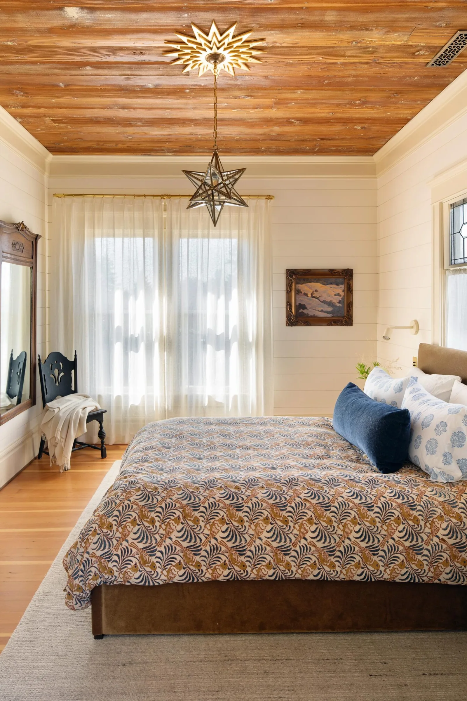 Bedroom featuring a wood plank ceiling with a star-shaped pendant light and sheer window curtains.