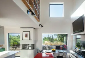 Modern kitchen and dining area with large picture and clerestory windows.