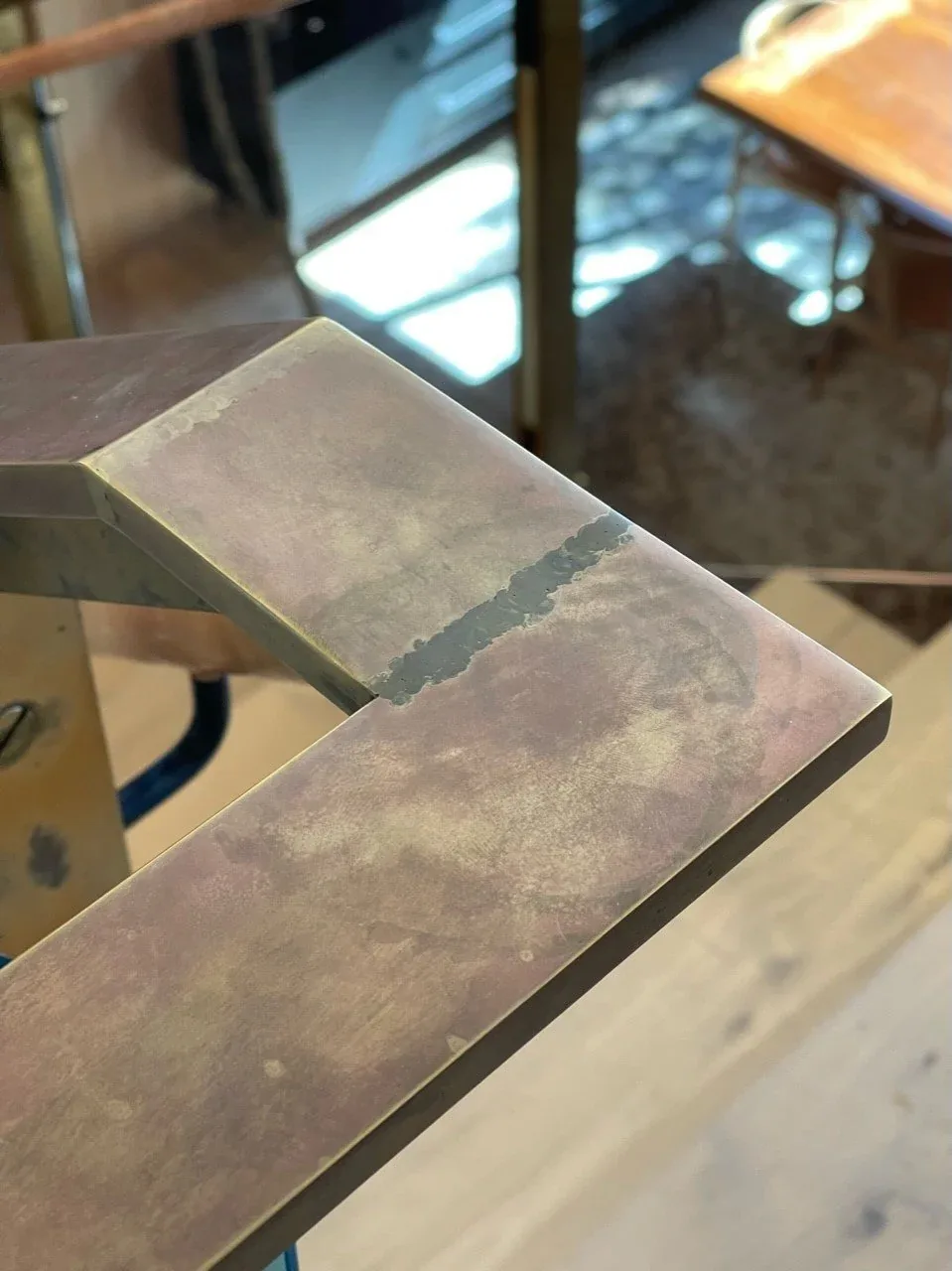 Detail of a welded metal stair railing with a patina finish.