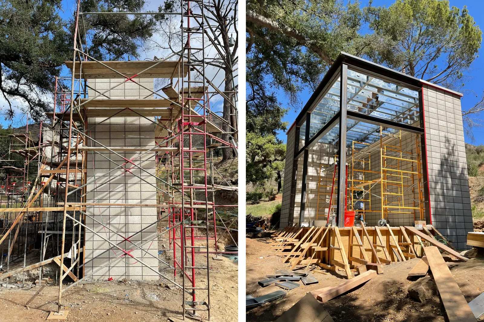 Block wall structure under construction surrounded by scaffolding and construction materials on a hillside site.