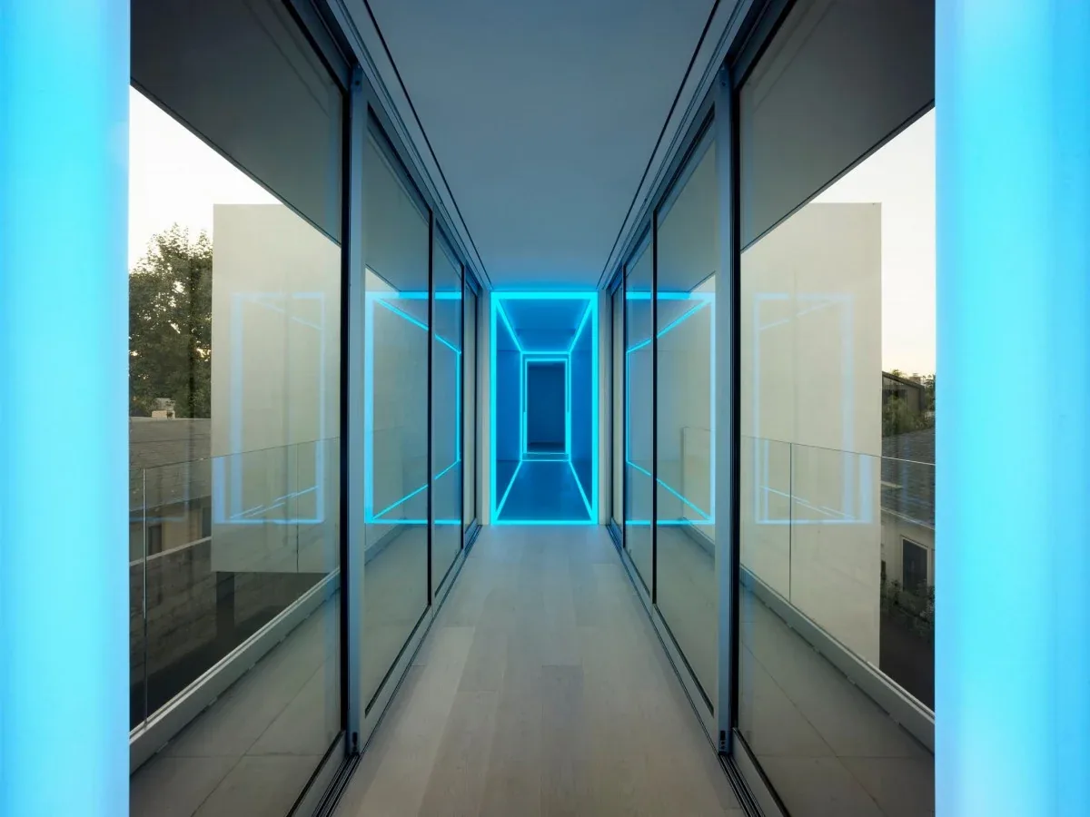Glass-enclosed corridor with blue LED lighting in the Spectral Bridge House.