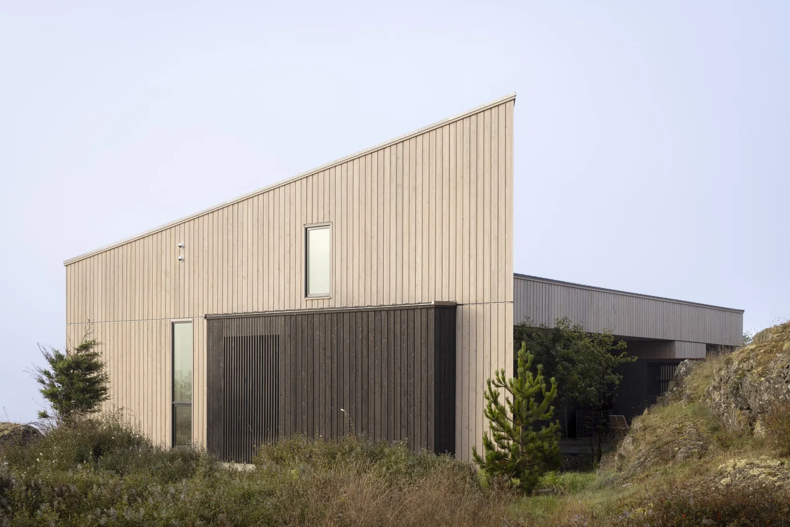 False Bay house by Heliotrope Architects has a modern exterior with vertical wood paneling and a sloped roof.