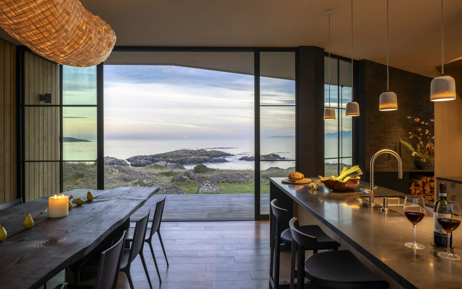 False Bay project kitchen and dining area featuring floor-to-ceiling glazing with views of rocky landscape and ocean.