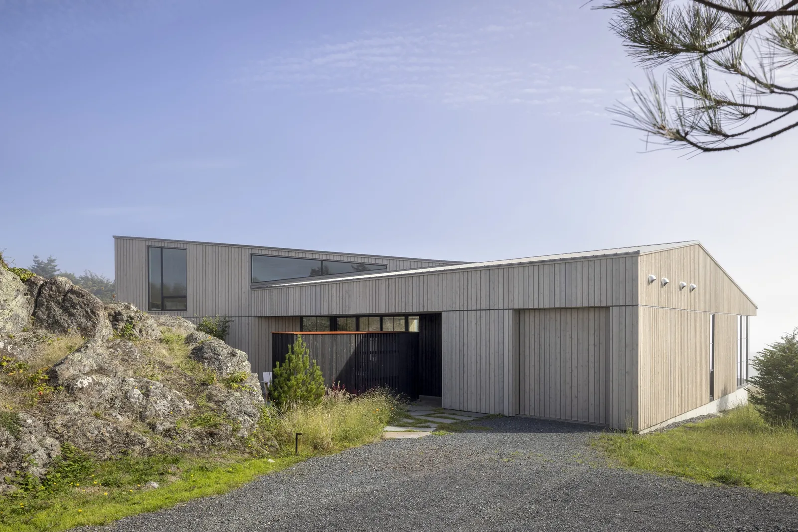False Bay project by Heliotrope Architects shows a modern home with vertical wood siding and angled rooflines.