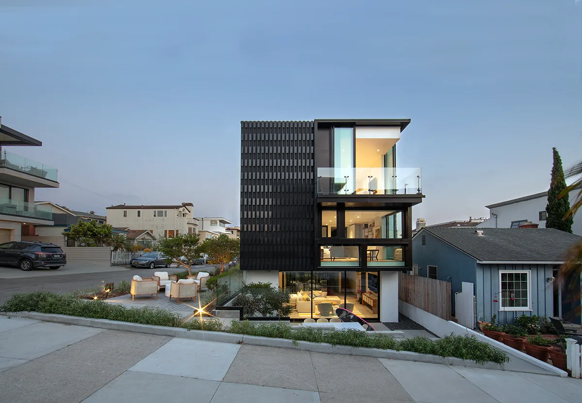 Alma Switch House features a tiered modern design with large windows and a black textured exterior wall.