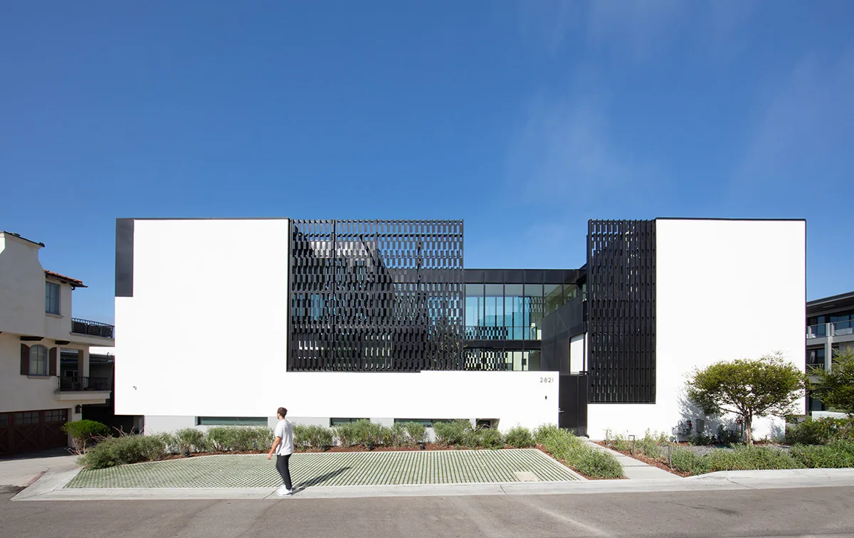 Front view of Alma Switch House showing white stucco walls and black metal lattice screens.