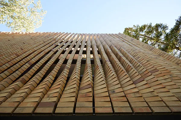 The facade of the Lipton Thayer House features curved vertical brick slats creating a textured surface.