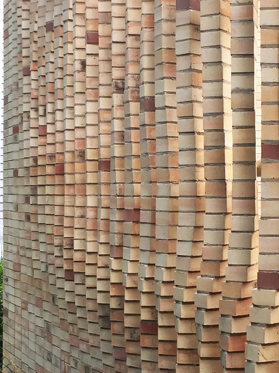 Curved brick facade with vertical brick projections at the Lipton Thayer House.