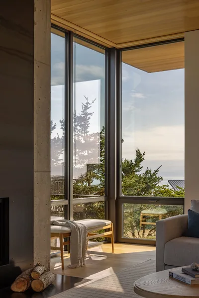 Living room corner with floor-to-ceiling windows providing exterior views and natural light.