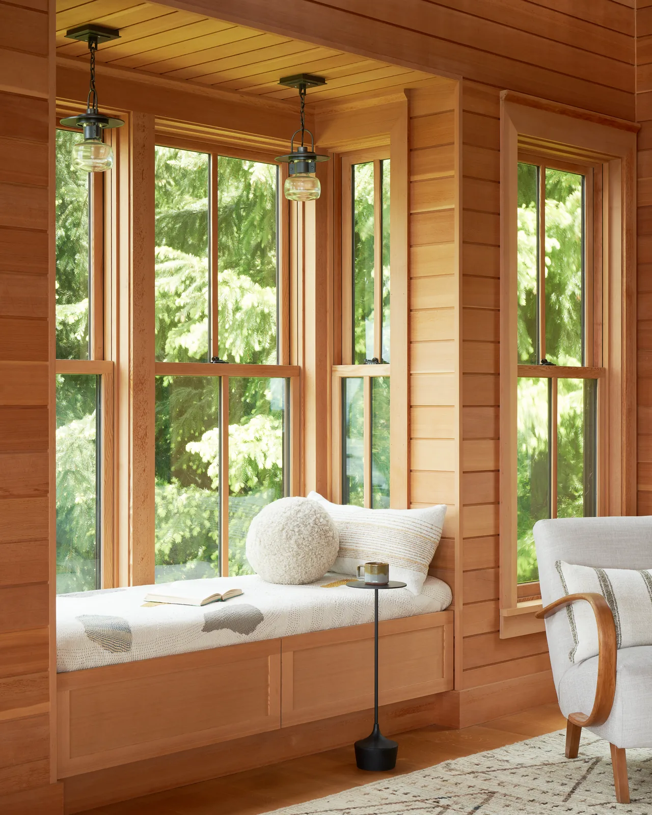 Built-in wood-paneled window bench area with natural light from multiple large windows.