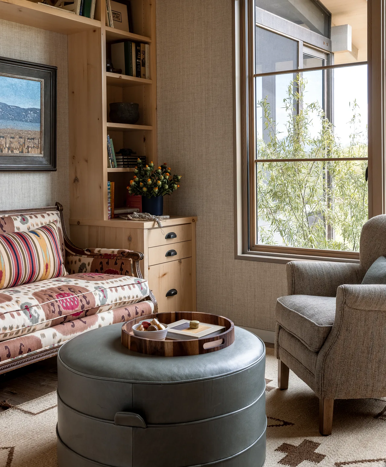 Living area in the Wyoming Retreat featuring a patterned sofa, wooden built-ins, and a large window with natural light