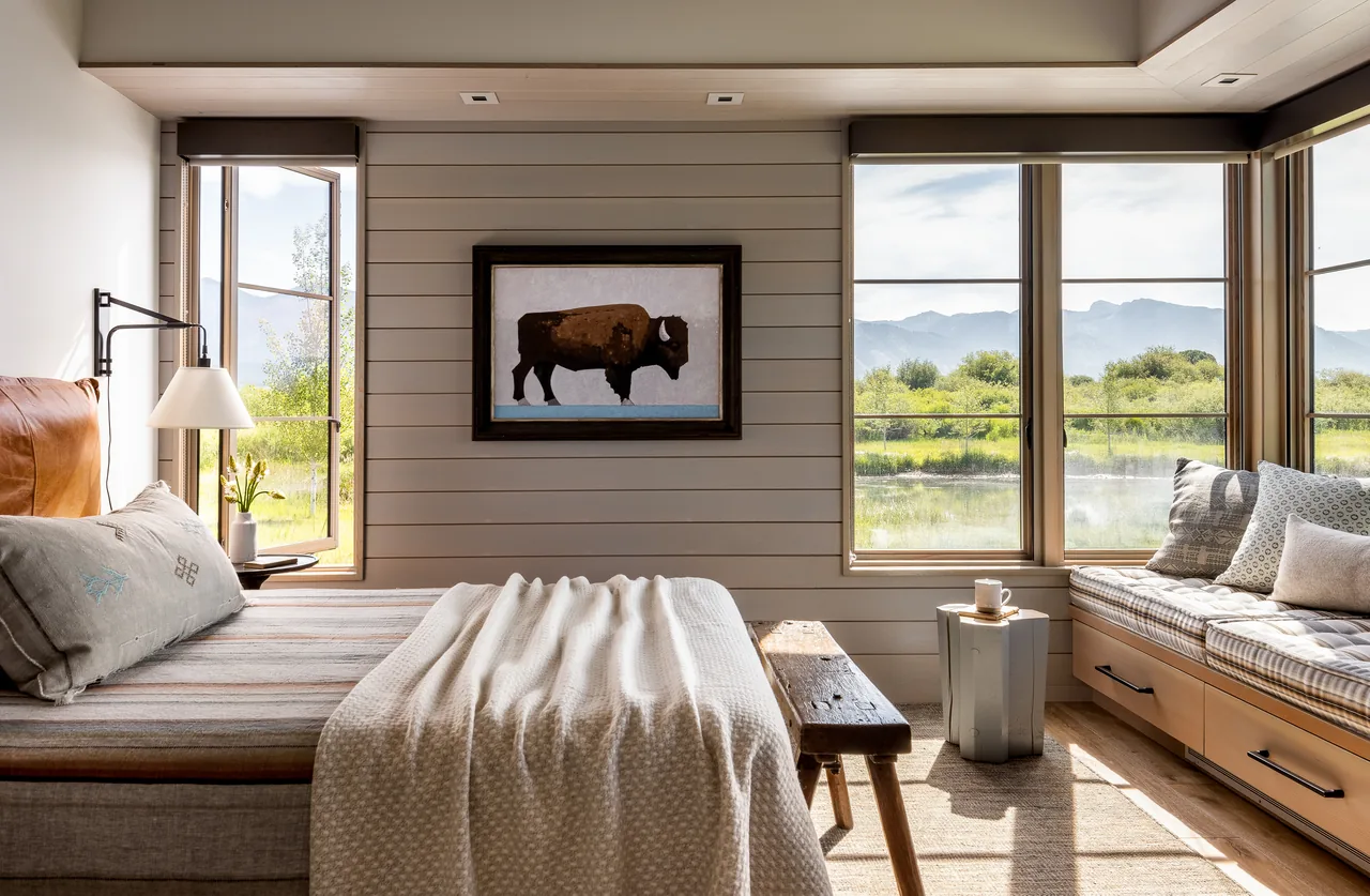 Bedroom in the Wyoming Retreat featuring large windows and a built-in window seat with storage drawers.