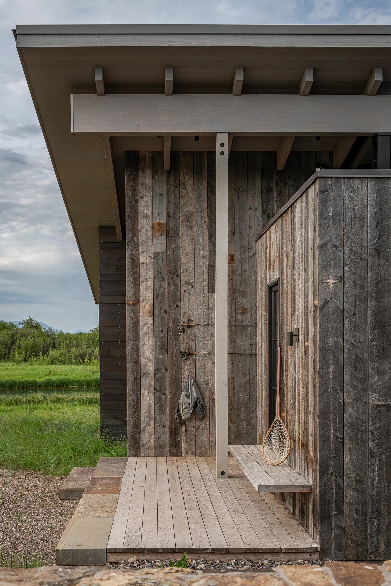 Wooden exterior wall and porch detail with weathered siding and roof overhang at Wyoming Retreat.