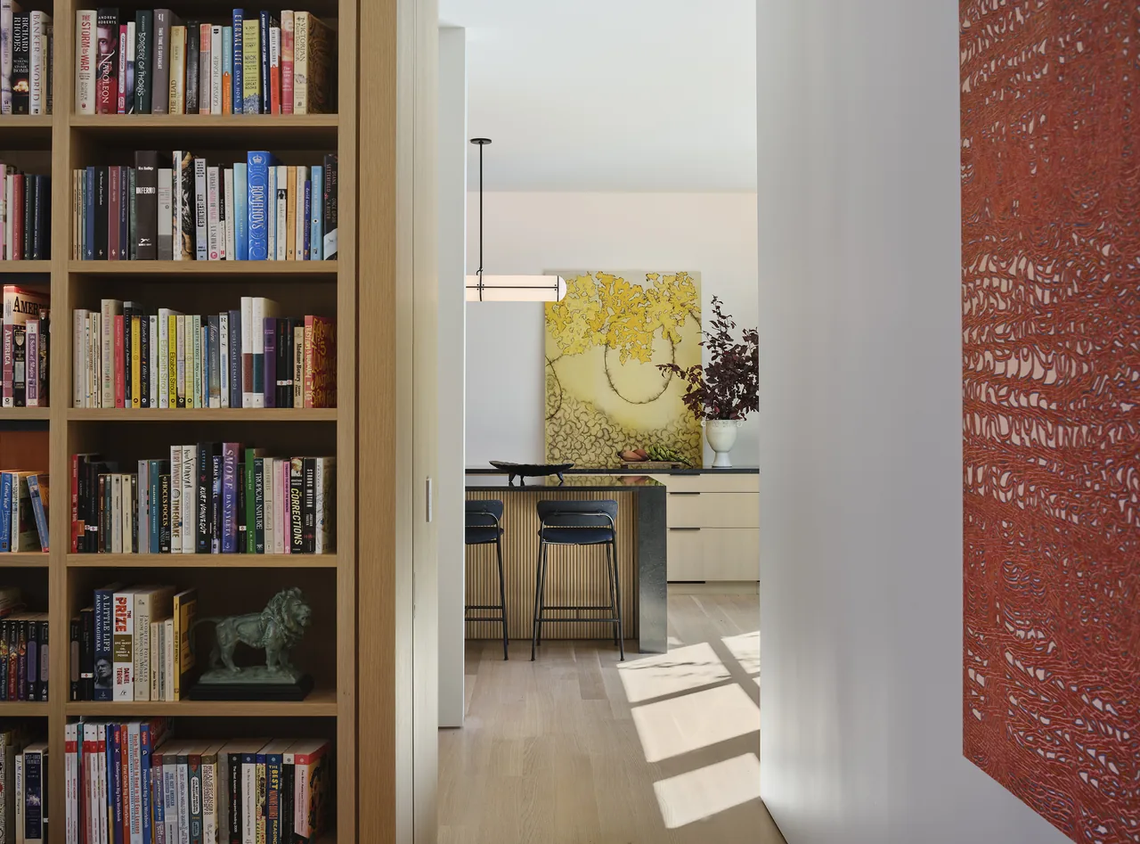 The Lakewood Balmoral Residence features a kitchen area visible from a hallway with built-in bookshelves and artwork.