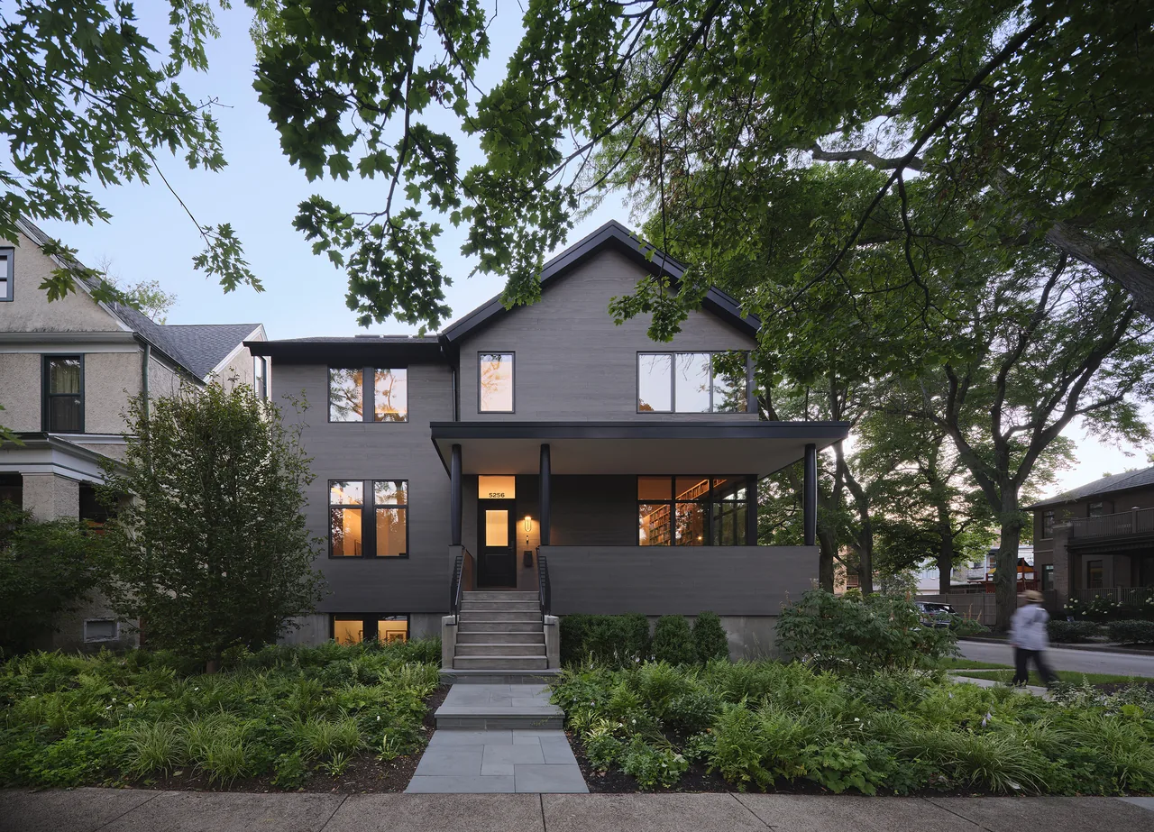 Front view of Lakewood Balmoral Residence showing a gray wood exterior with large windows and a covered porch.