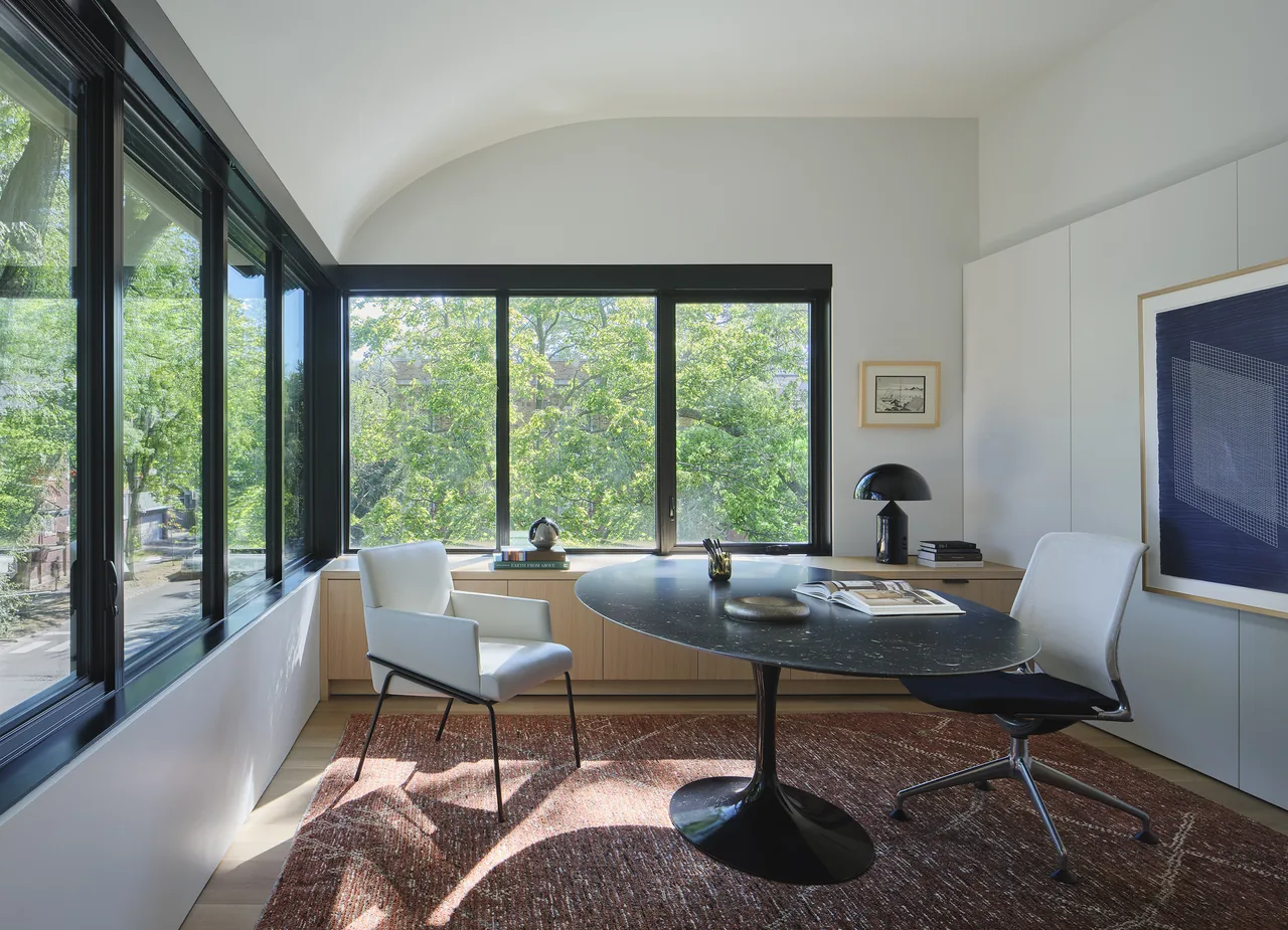 Office space featuring corner windows and a vaulted ceiling with minimal furnishings.